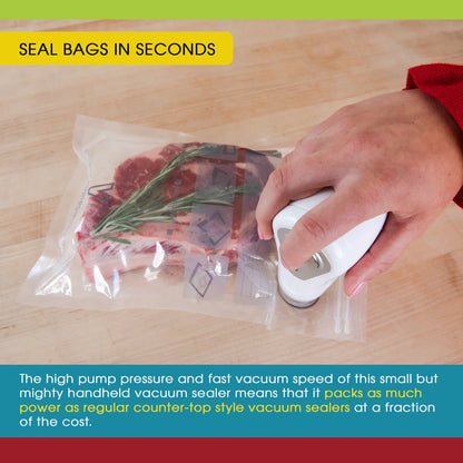 Hand using a small vacuum sealer to seal a bag of food on a wooden surface.